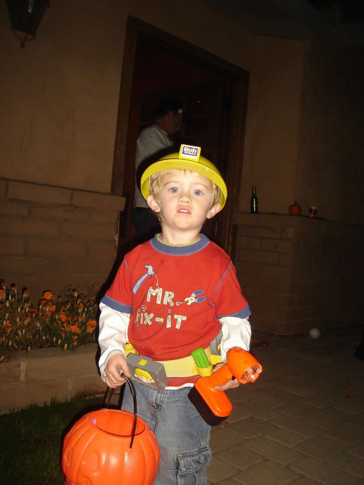 Toddler Scott in a Mr. Fix-It Halloween costume with hard hat, tool belt, and pumpkin bucket