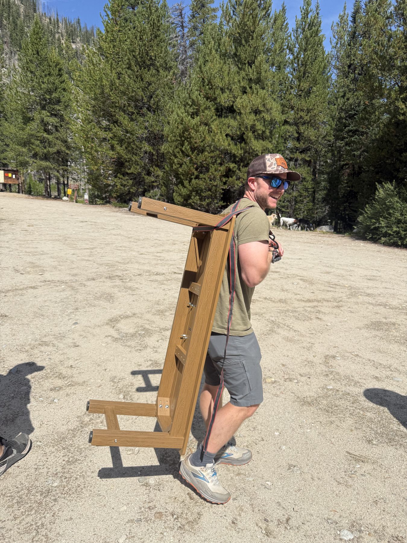 Carrying the bench in on one shoulder, headed for the trail