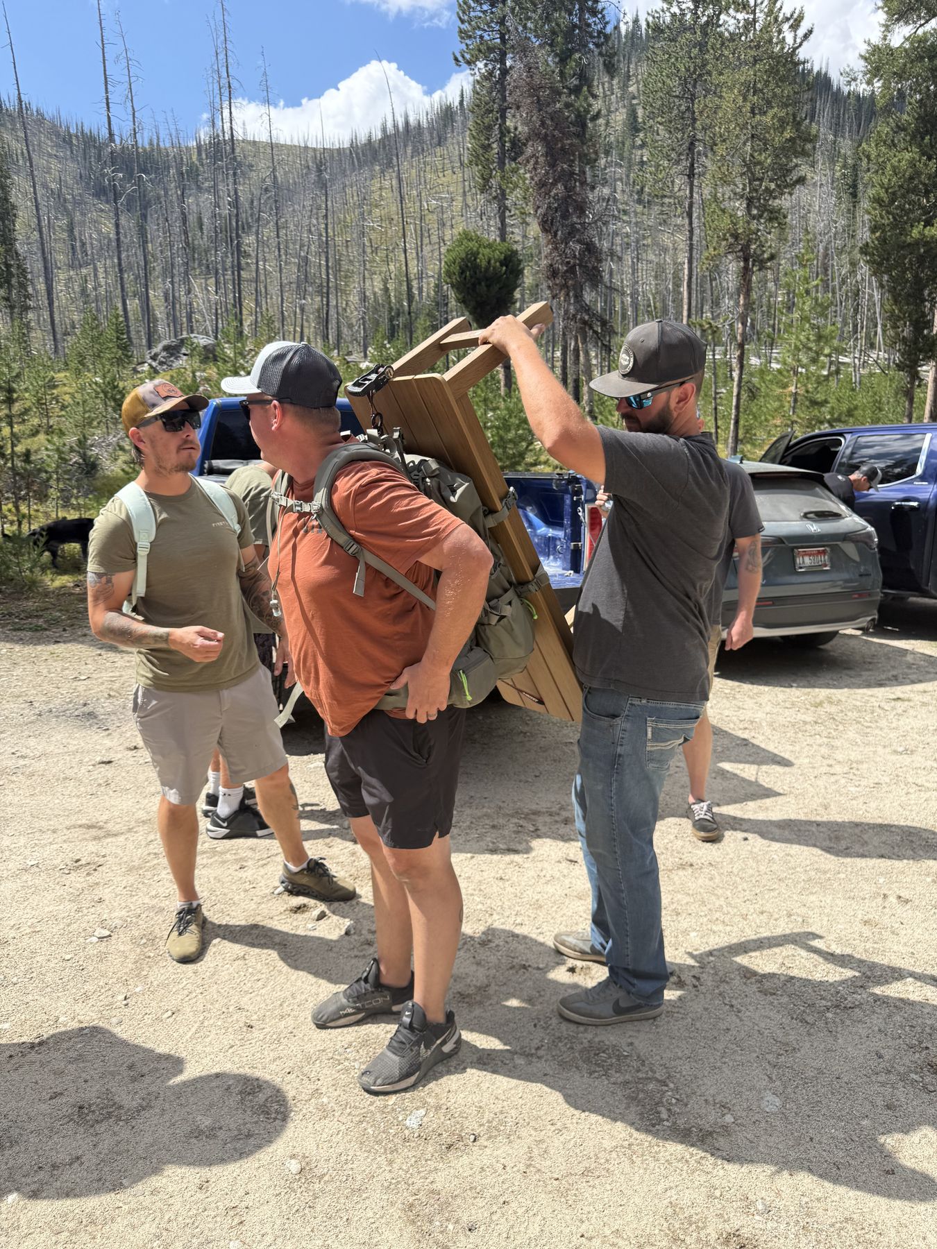 Unloading the bench from the back of a truck at the trailhead